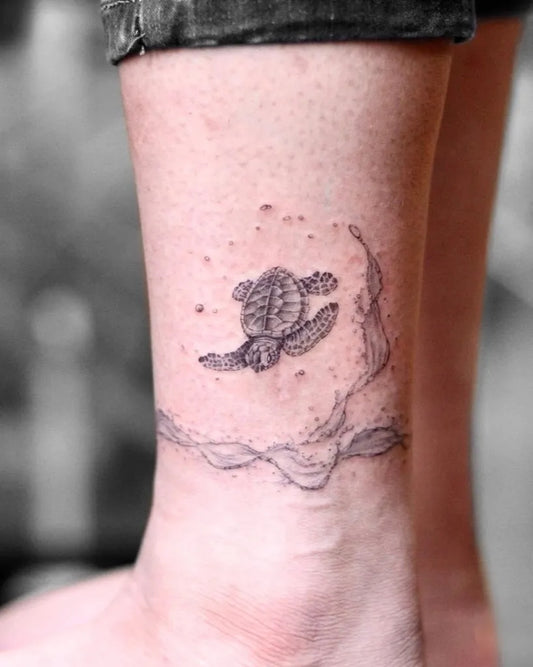 Small Black and Grey Turtle and Waves Tattoo on Women Ankle by @eggsy_tattoo