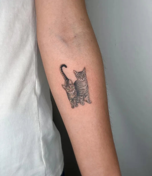 Small Black and Grey Two Cats Tattoo on Women Arm by @disegnarti
