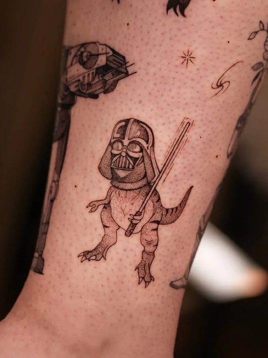 Small Black and Grey Vader T Rex Star Wars Tattoo on Women Leg by @mariafernandeztattoo