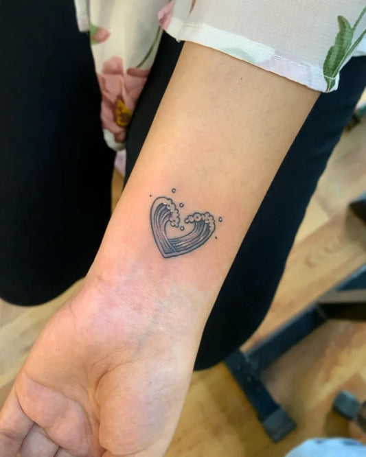 Small Black and Grey Wave Heart Tattoo on Women Wrist by @pro_tattoo_studio