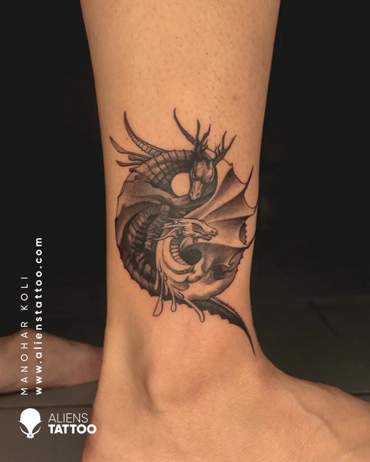 Small Black and Grey Yin Yang Dragon Tattoo on Women Ankle by @alienstattooindia