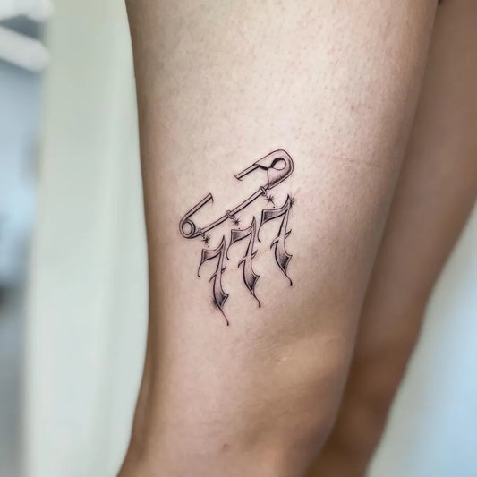 Small Blackwork 777 Safety Pin Tattoo on Women Thigh by @raybies.ink