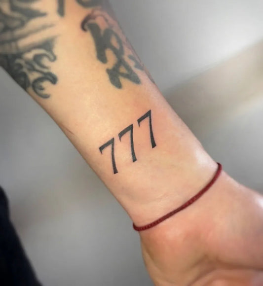 Small Blackwork 777 Tattoo on Men Wrist by @pattqa.tattooo