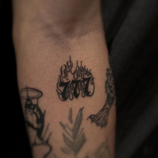 Small Blackwork 777 and Flames Tattoo on Men Forearm by @gabi_darkart