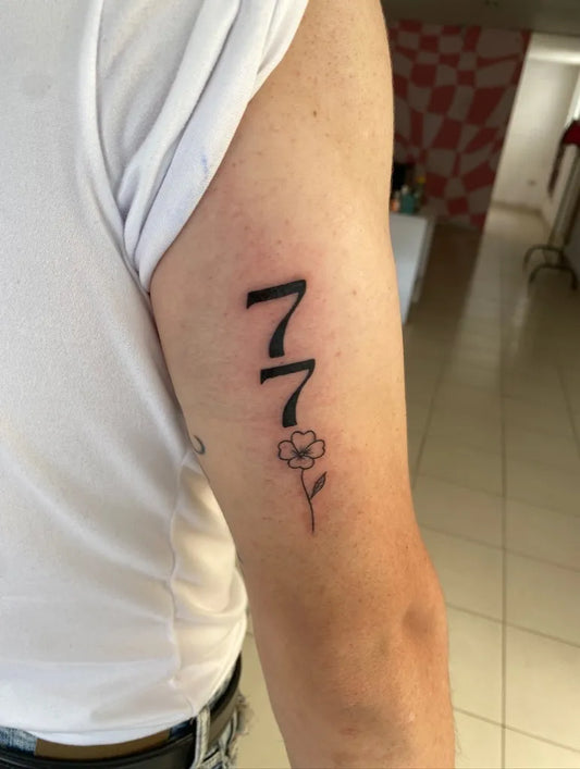 Small Blackwork 777 and Flower Tattoo on Men Arm by @ammihs_tattoo