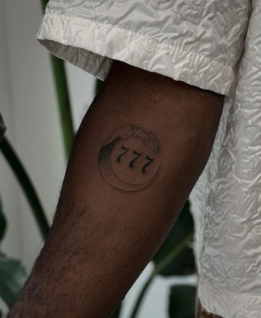 Small Blackwork 777 in Circle Tattoo on Men Forearm by @fleurnoiretattoo