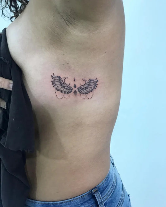 Small Blackwork Angel Wings with Dots and Chains Tattoo on Women Side by @kathrynrose_tattoo