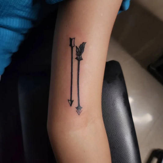 Small Blackwork Arrow Tattoo on Women Arm by @livingthroughart__