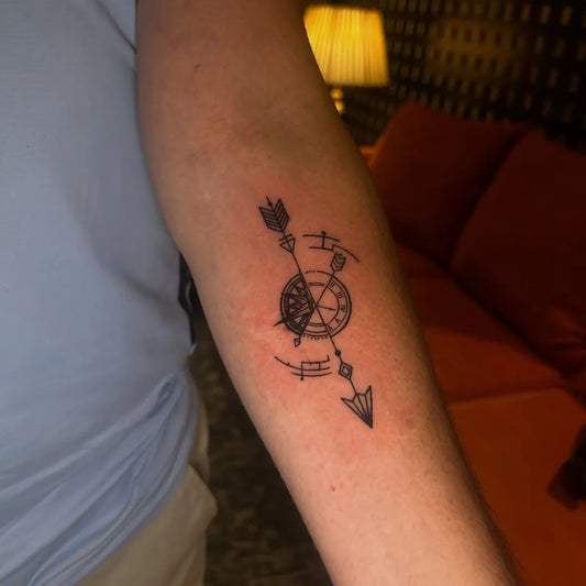 Small Blackwork Arrow and Compass Tattoo on Women Arm by @chd.edentattoos