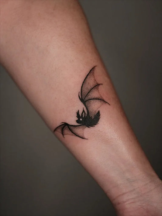 Small Blackwork Bat Tattoo on Women Arm by @inkedbydorigen