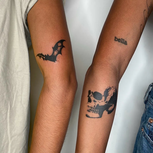 Small Blackwork Bat and Skull Tattoo on Women Arm by @darkfaetattoo