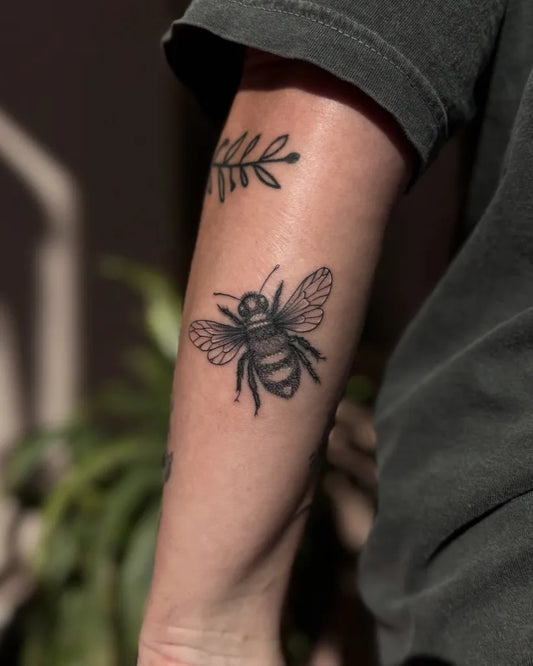Small Blackwork Bee Laurel on Women Arm Tattoo by @tattooedbyceci