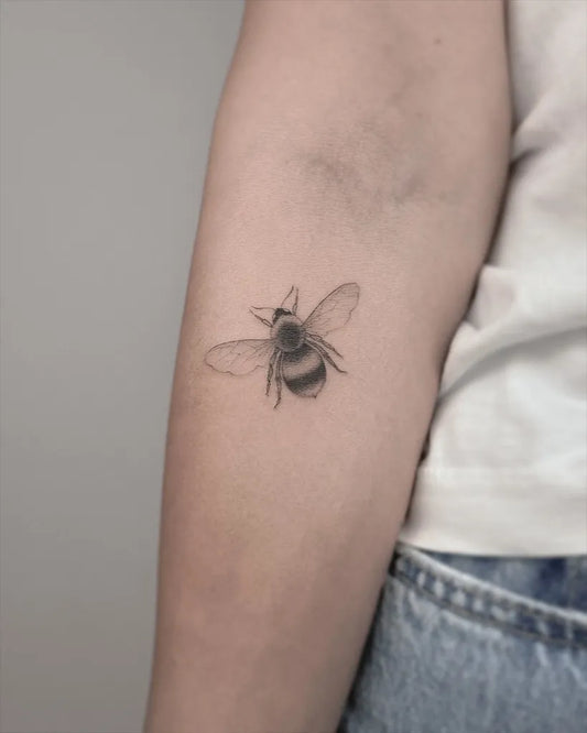 Small Blackwork Bee on Women Arm Tattoo by @eden_tattoos
