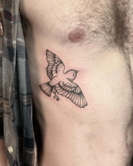 Small Blackwork Bird Tattoo on Men Rib by @eleanoronyx