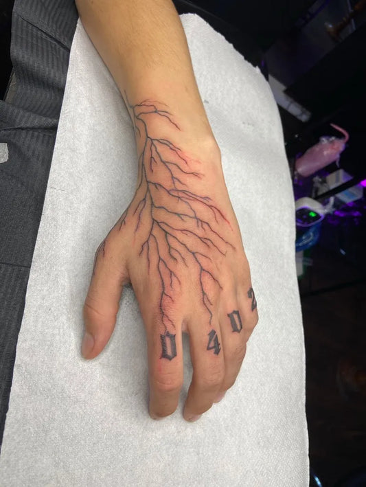 Small Blackwork Branch and 104 on Men Hand Tattoo by @_k.ink__