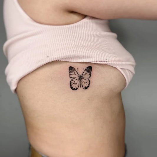 Small Blackwork Butterfly Tattoo on Women Rib by @isabelasainz___ttt