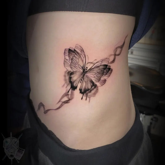 Small Blackwork Butterfly Tattoo on Women Rib by @rocky_esparza_tattoos