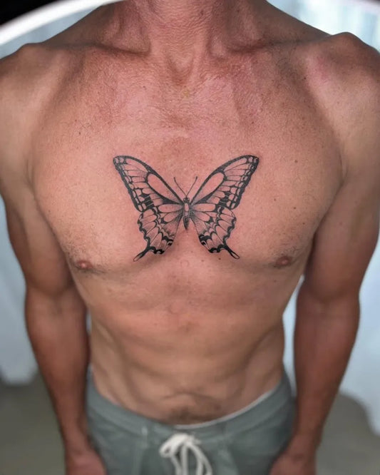 Small Blackwork Butterfly on Men Sternum Tattoo by @your_neighbourhood_studio