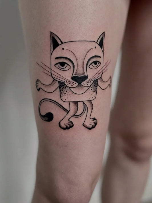 Small Blackwork Cartoon Cat Tattoo on Women Thigh by @toka_designs.tattoo