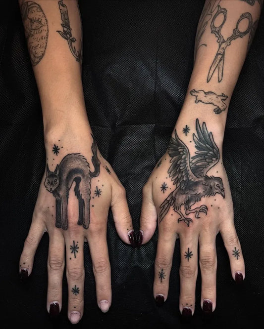 Small Blackwork Cat and Raven on Women Hands Tattoo by @poison.well