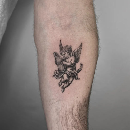 Small Blackwork Cherub Tattoo on Men Arm by @sakira.sky.tattoo