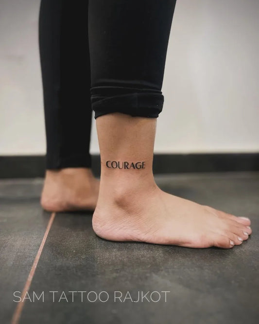 Small Blackwork Courage Quote Tattoo on Women Ankle by @pratik_kadvatar