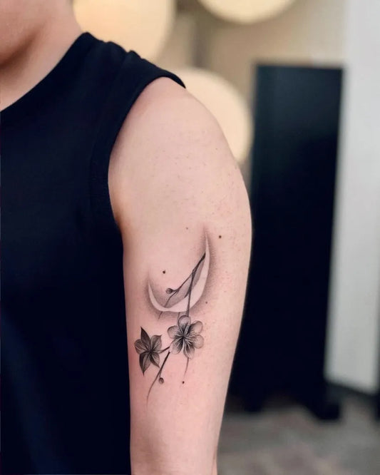 Small Blackwork Crescent Moon and Flowers Tattoo on Men Upper Arm by @garden_tgcs