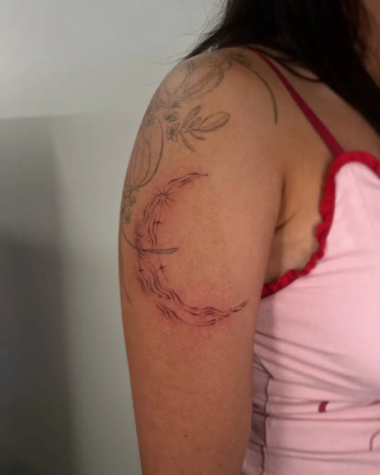 Small Blackwork Crescent Moon and Flowers Tattoo on Women Shoulder by @ktt.tattoo
