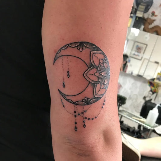 Small Blackwork Crescent Moon and Mandala Tattoo on Women Arm by @auburn_ink