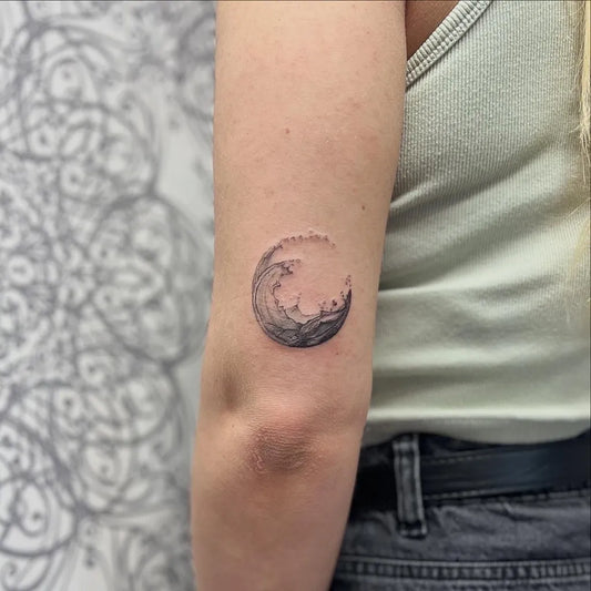 Small Blackwork Crescent Moon with Wave Tattoo on Women Arm by @sina.welcher.kosmetik.tattoo