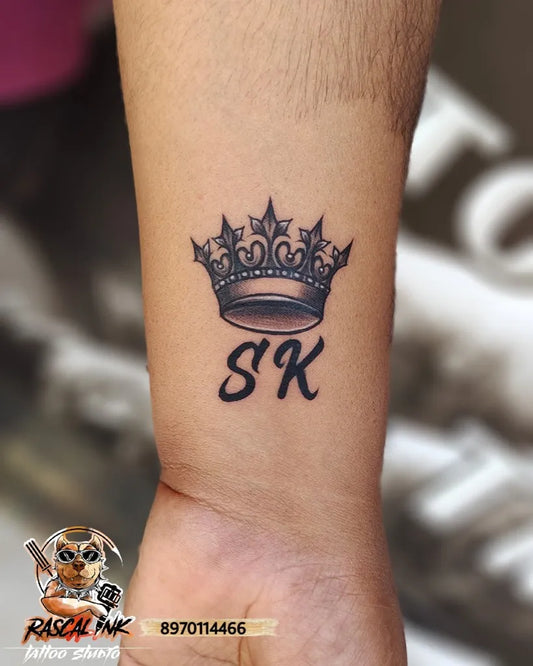 Small Blackwork Crown and Initials Tattoo on Men Wrist by @rascalinktattoos
