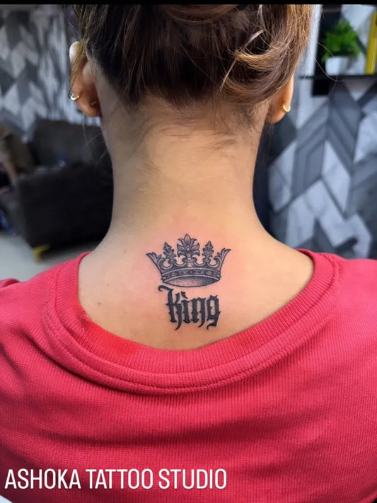 Small Blackwork Crown and King Tattoo on Women Neck by @ashokatattoomumbai