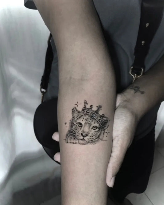Small Blackwork Crowned Cub Tattoo on Women Arm by @kwitsuit