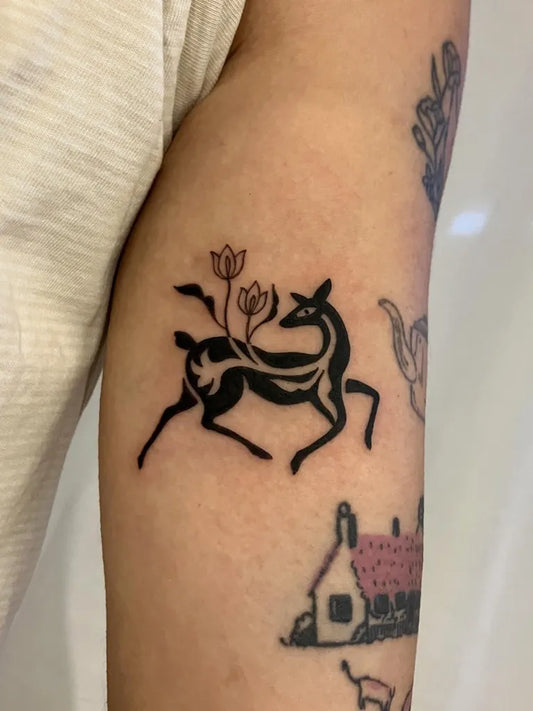 Small Blackwork Deer and Flowers Tattoo on Women Arm by @reena.tattoo