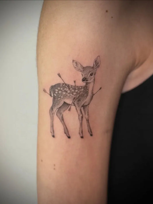 Small Blackwork Deer with Arrows Tattoo on Women Upper Arm by @gagemansfield.tattoos