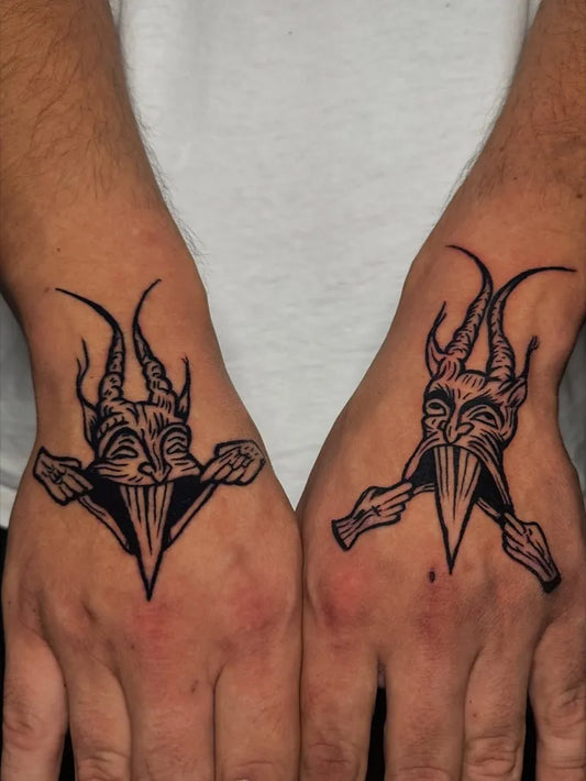 Small Blackwork Demon Mask Tattoo on Men Hands by @elgallo_tattoo_