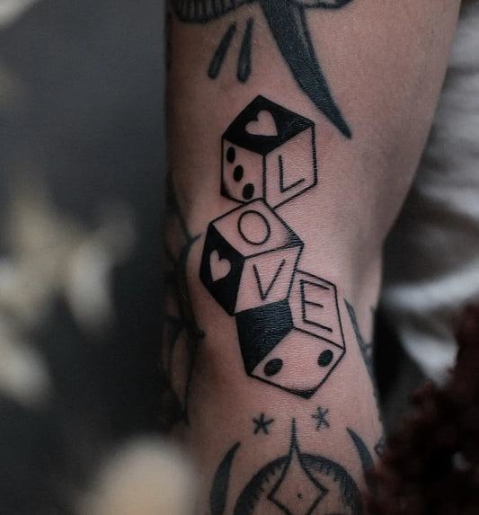 Small Blackwork Dice and Love Tattoo on Men Arm by @mariogrimmtattoo