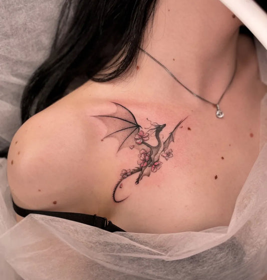Small Blackwork Dragon and Cherry Blossom on Women Shoulder Tattoo by @nicksik_tattoo