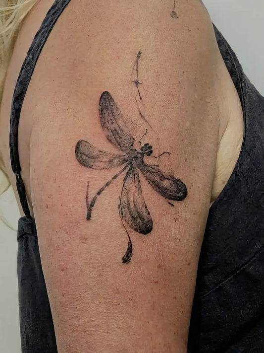 Small Blackwork Dragonfly on Women Shoulder Tattoo by @rudrainktattoo