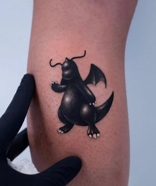 Small Blackwork Dragonite Tattoo on Men Leg by @pokemon.tatts