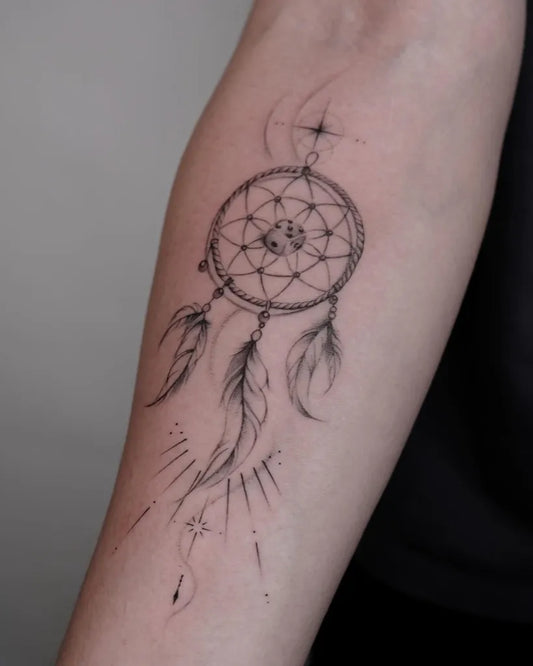 Small Blackwork Dream Catcher with Feathers Tattoo on Women Forearm by @ink.carolw