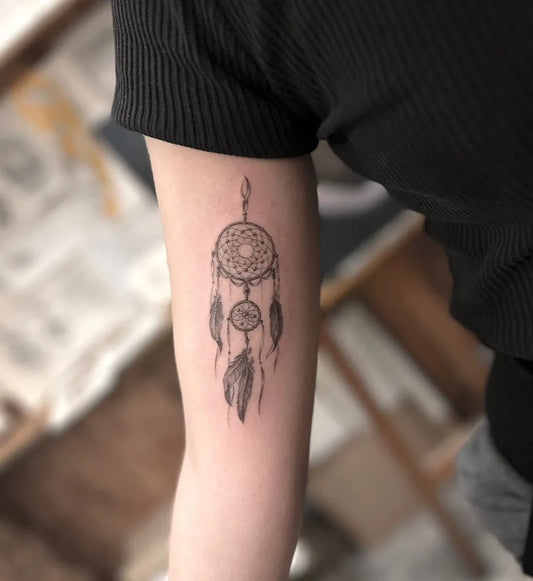 Small Blackwork Dreamcatcher Tattoo on Women Arm by @tattoograin