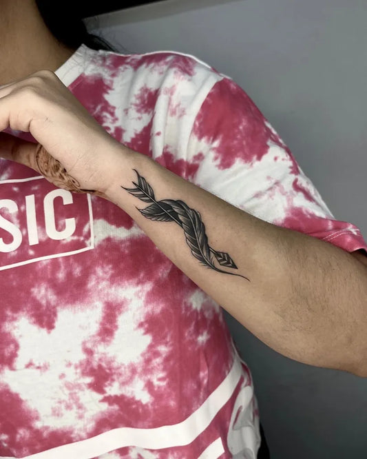 Small Blackwork Feather Tattoo on Women Forearm by @kamayatattoostudio