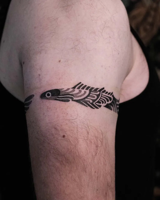 Small Blackwork Fish Tattoo on Men Upper Arm by @noso.universe