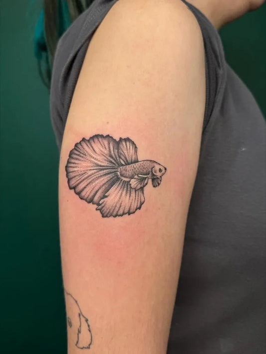 Small Blackwork Fish Tattoo on Women Arm by @smolenaers.tattoo