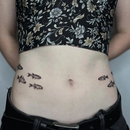 Small Blackwork Fish Tattoo on Women Stomach by @soulpurposetattoo