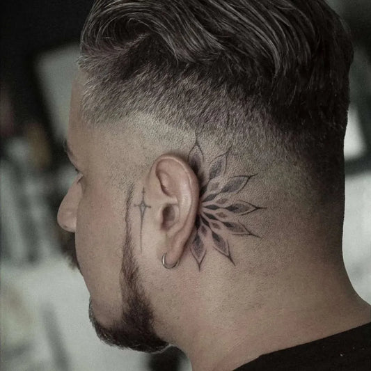 Small Blackwork Flower Tattoo on Men Behind the Ear by @inkedarts