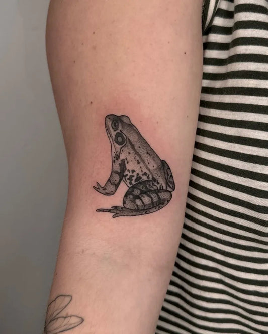 Small Blackwork Frog Tattoo on Women Arm by @dusty.tats