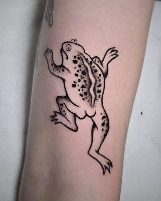 Small Blackwork Frog Tattoo on Women Arm by @ripley.ltm.tattoo