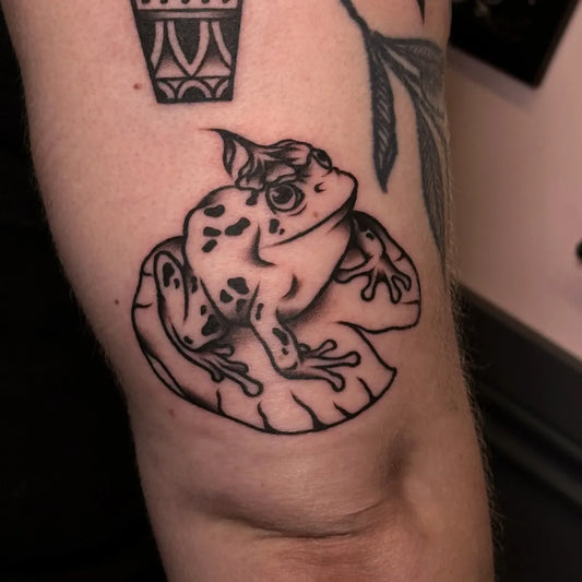 Small Blackwork Frog and Lily Pad Tattoo on Women Knee by @tireddeye